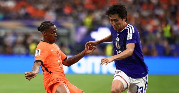 Spielszene aus dem WM-Duell Niederlande gegen Japan mit Zweikampf zwischen zwei Spielern auf dem Fußballfeld