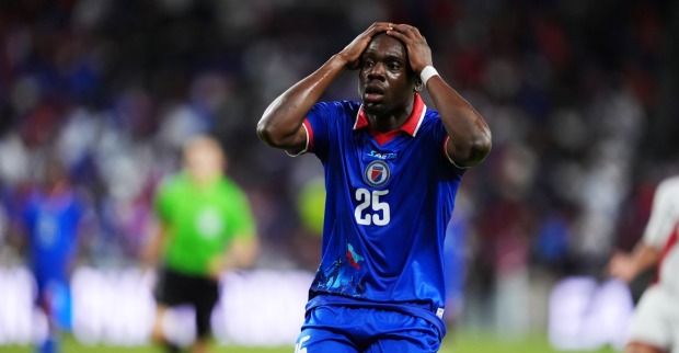 Haiti-Nationalspieler im blauen Trikot mit historischer Illustration, FIFA verbietet das WM-Trikot vor Turnierbeginn.