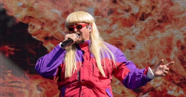 Oliver Tree singt auf der Bühne mit Mikrofon und auffälligem Outfit während eines Konzerts