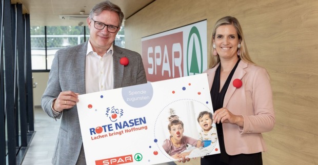 Zwei Menschen halten ein Schild in die Höhe