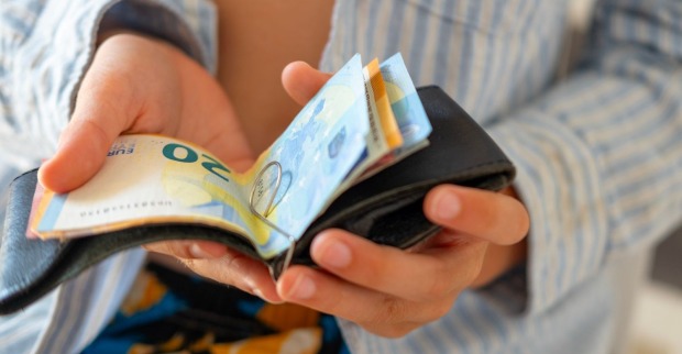 Schüler zählt Euro-Geld aus Geldbörse als Symbol für fehlende Finanzbildung bei Jugendlichen
