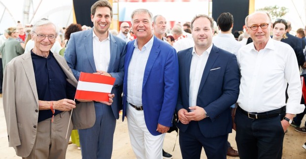 Fünf Prominente Herren in sommerlichen Outfits und mit einer Österreich-Flagge