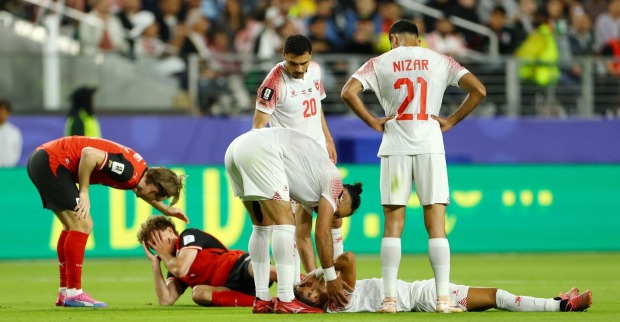 Stefan Posch liegt verletzt am Boden nach Kopf-Zusammenstoß, Spieler stehen besorgt um ihn herum bei WM-Spiel Österreich gegen Jordanien.
