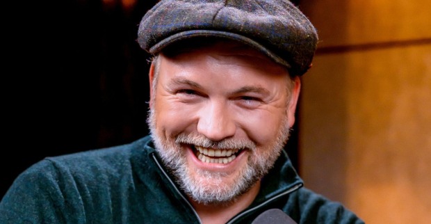 Thomas Stipsits lächelt bei einem öffentlichen Auftritt in die Kamera und trägt eine dunkle Schiebermütze sowie einen Bart./ Thomas Stipsits wird für seinen neuen Kinofilm „Italien oder Non mio Esolo“ zum Schlagerstar