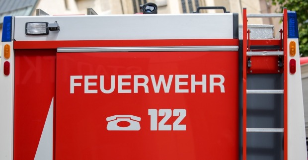 Feuerwehrauto mit deutschem Feuerwehrschild und Notrufnummer 122.