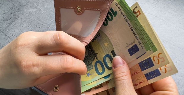 Bonuszahlung Österreich 2026 – Hand zieht Euro-Geldscheine aus Geldbörse als Symbol für steuerfreie Mitarbeiterprämie bis 500 Euro