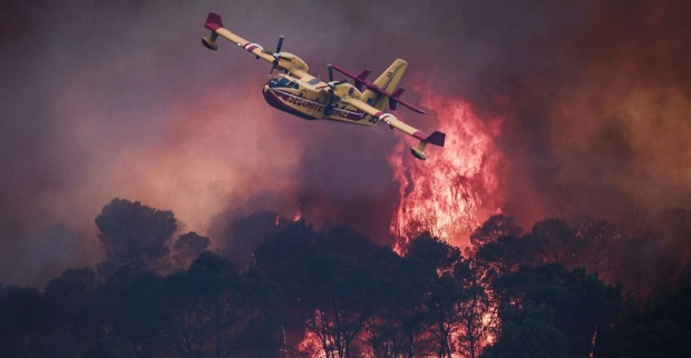 Einsatzkräfte kämpfen aus der Luft gegen die Flammen.