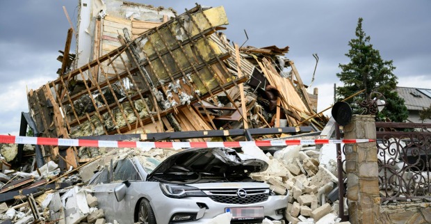 Zerstörtes Haus nach Gasexplosion in Floridsdorf mit Trümmern und beschädigtem Auto im Vordergrund
