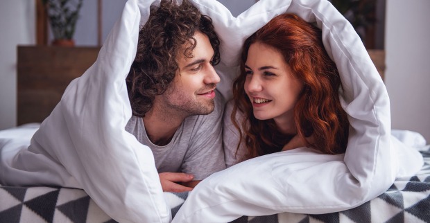 Frau und Mann unter der Bettdecke | Credit: George Rudy/Shutterstock