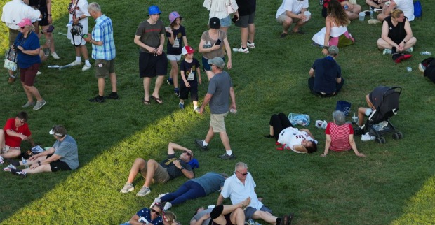 Menschen rasten in einem Park im Schatten.