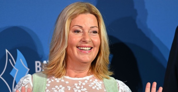 Blonde Frau im Dirndl lächelt in die Kamera