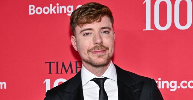 MrBeast (Jimmy Donaldson) posiert in schwarzem Anzug und Krawatte auf einem roten Teppich. Der YouTube-Star hat seine langjährige Freundin Thea Booysen geheiratet.