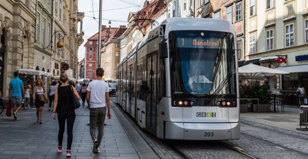 Eine Straßenbahn der Linie 1 fährt durch die Straßen von Graz