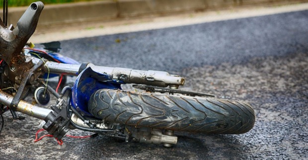 Ein beschädigtes Motorrad liegt nach einem schweren Verkehrsunfall am Straßenrand