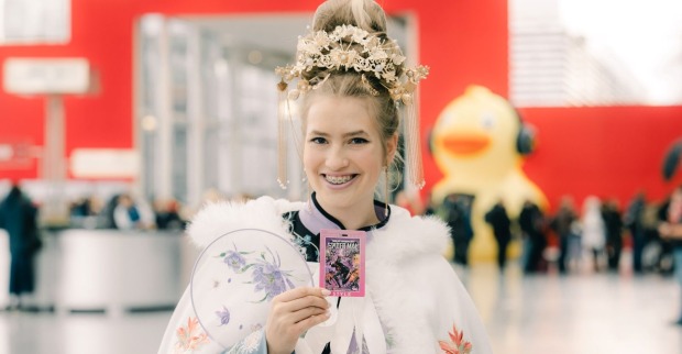 junge, blonde Vienna Comic Con-Teilnehmerin im Kostüm und mit Kopfschmuck