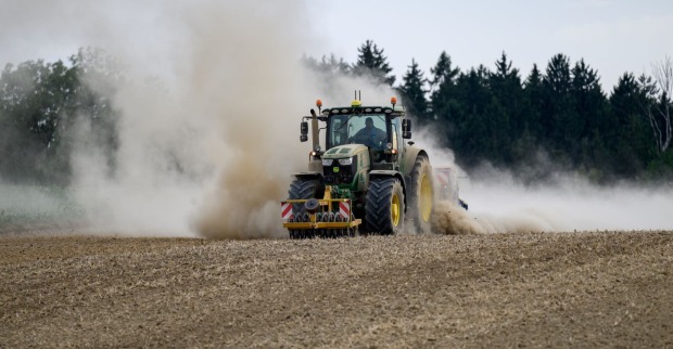 Traktor fährt über ein ausgetrocknetes Feld während der Dürre in Österreich 2026.