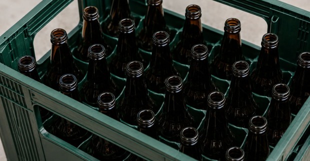 Bierkiste mit leeren Bierflaschen als Symbolbild für einen Pfandbetrug mit 91 Euro in der Steiermark.