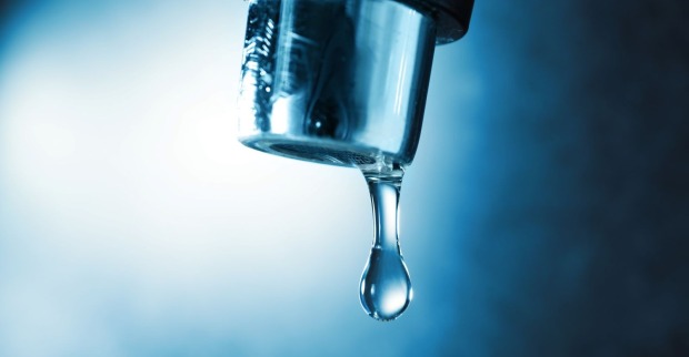 Ein geöffneter Wasserhahn, aus dem ein spärlicher Wasserstrahl fließt