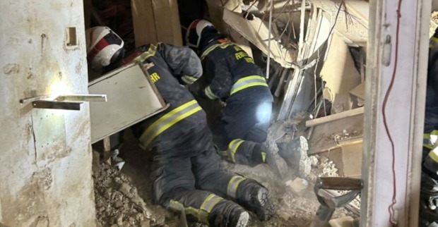 Feuerwehrleute suchen nach dem Hauseinsturz in der Wiener Färbergasse zwischen Trümmern und Mauerteilen.