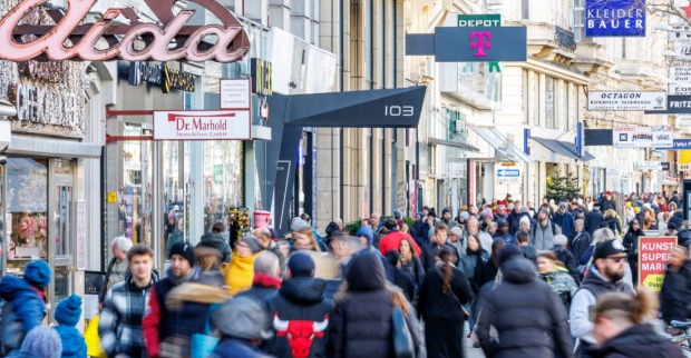 Sonntagsöffnung in Österreich: Belebte Einkaufsstraße mit zahlreichen Geschäften und Passanten