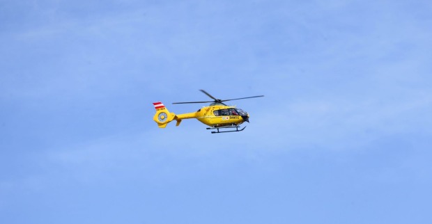 Gelber Rettungshubschrauber fliegt durch die Luft
