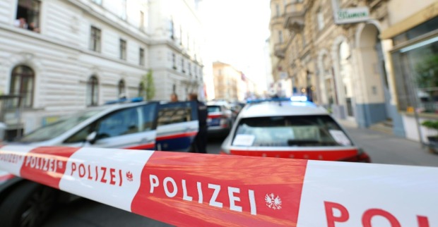 Mehrere Polizeiautos und ein Absperrband vor einer Wohnung