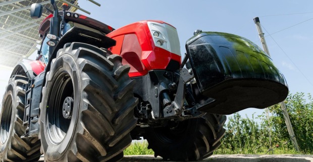 Roter Traktor steht an der Seite eines Feldes