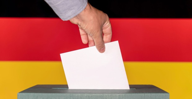 Stimmzettel der in eine Urne eingeworfen wird