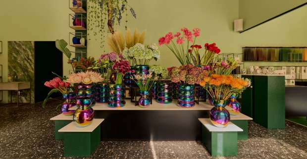 Blumen in regenbogenfarbenen Vasen in einem Blumengeschäft