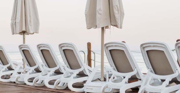Leere Sonnenliegen und Sonnenschirme an einem Strand – Symbolbild zum tödlichen Streit um eine Sonnenliege in Griechenland.