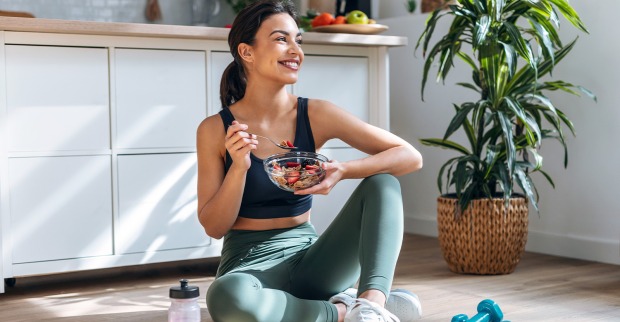 Junge Frau in Trainingskleidung mit Salat in der Hand | Credit: Josep Suria/Shutterstock
