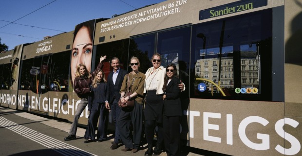 Gruppenbild vor gebrandeter Straßenbahn