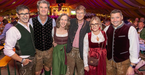 Sechs Personen in Tracht vor Werbebannern im Festzelt