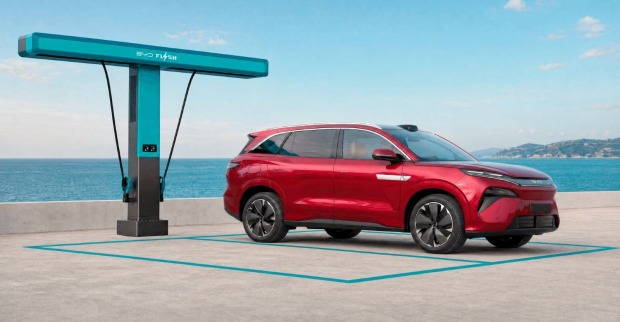 Rendering-Ansicht des BYD Atto 8 vor einer Meereskulisse mit Ladestation