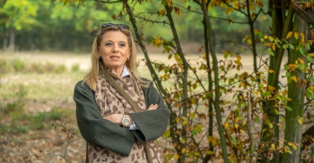 Christa Kummer, ehemalige ORF-Wetterfee, steht mit verschränkten Armen in herbstlicher Natur. Auf Instagram spricht sie über das Loslassen und weniger Ballast im Leben.
