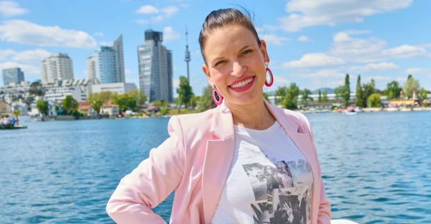 Dancing-Stars-Tänzerin Conny Kreuter lächelt in einem rosa Blazer in die Kamera. Die ORF-Bekanntheit ist Mama geworden und freut sich über die Geburt ihrer Tochter Luna.