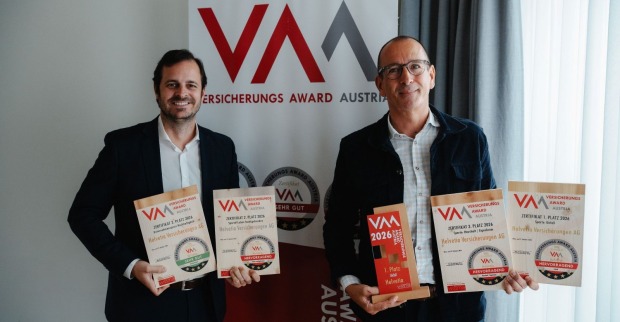 Zwei lachende Herren im Anzug halten die Award-Zertifikate in Händen.