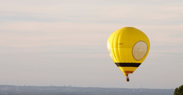Ein gelber Heißluftballon in der Luft.