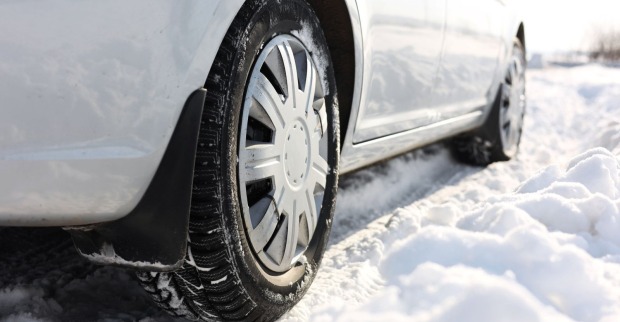 Auto mit Winterreifen auf einer beschneiten Straße
