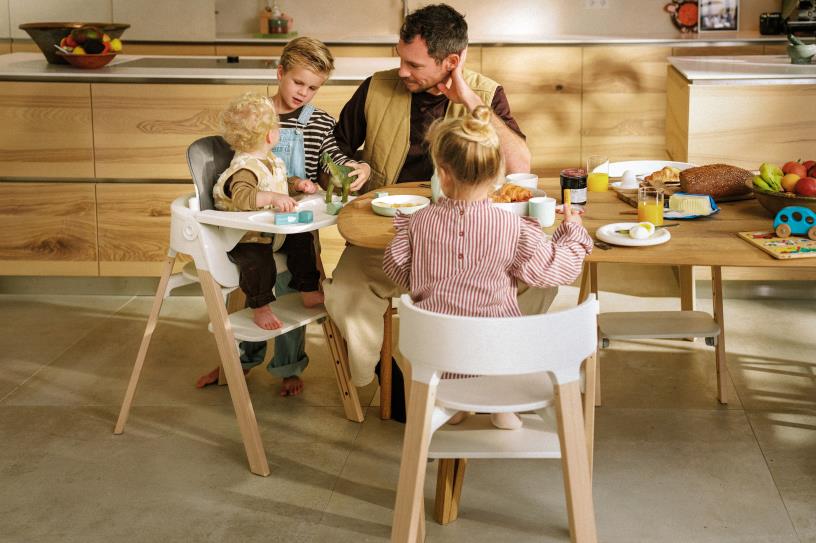 Stokke Steps podporuje spoločné stolovanie a blízkosť pri stole Rodina pri stole so stoličkou Stokke Steps počas spoločného jedla
