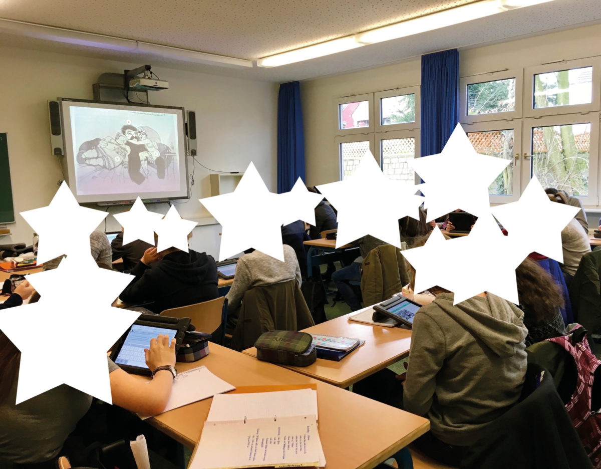 Eine Klasse sieht sich Inhalte zum Thema Nationalsozialismus an. Die Gesichter der Kinder sind aus Datenschutzgründen von weißen Sternformen überlagert.
