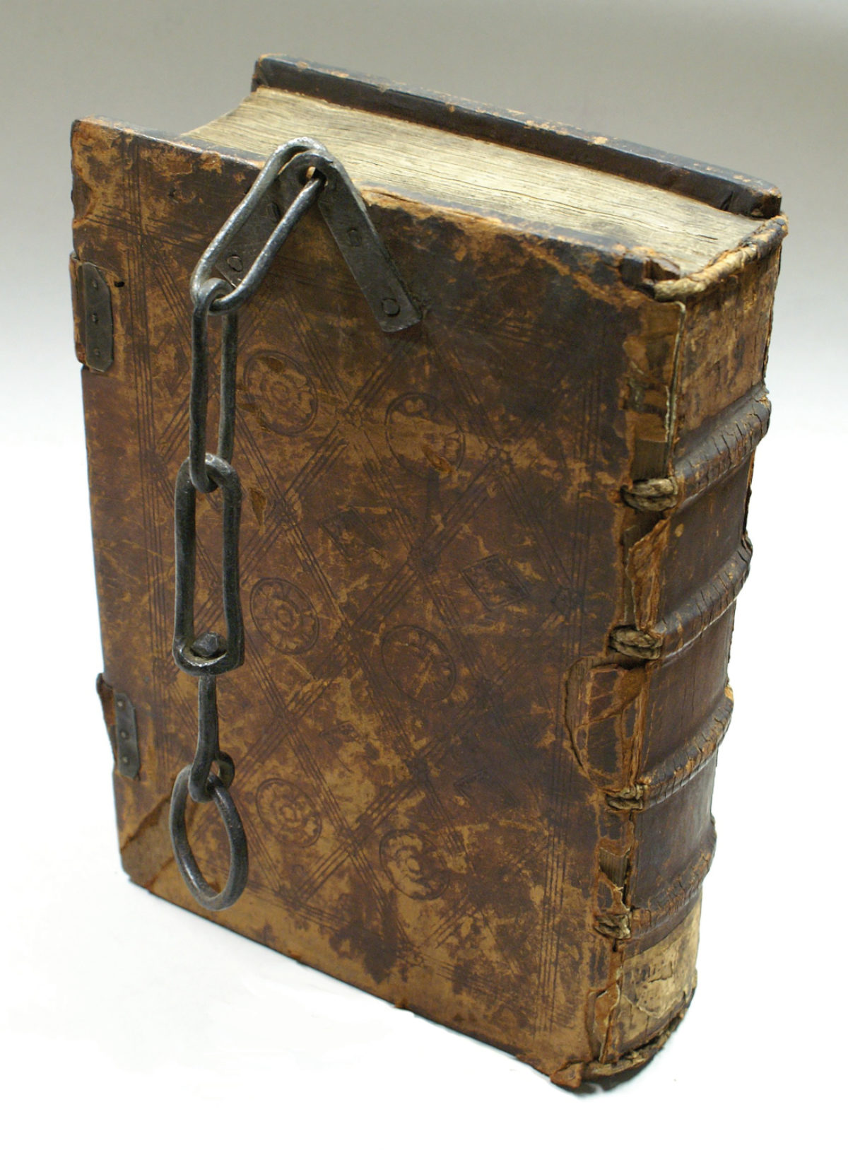 Ein altes Buch mit Ledereinband ist zu sehen, das Buch kann mithilfe einer Eisenkette verschlossen werden, ein sogenanntes Kettenbuch.