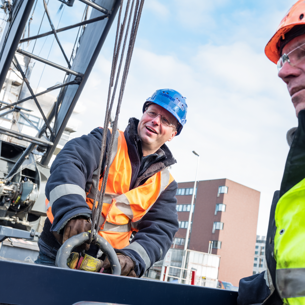 Medewerker ontvangt uitleg over de Nederlandse certificering en regelgeving voor hijskranen tijdens een praktijkgerichte veiligheidstraining van Hijsconcurrent, met focus op naleving en veilig hijsen.