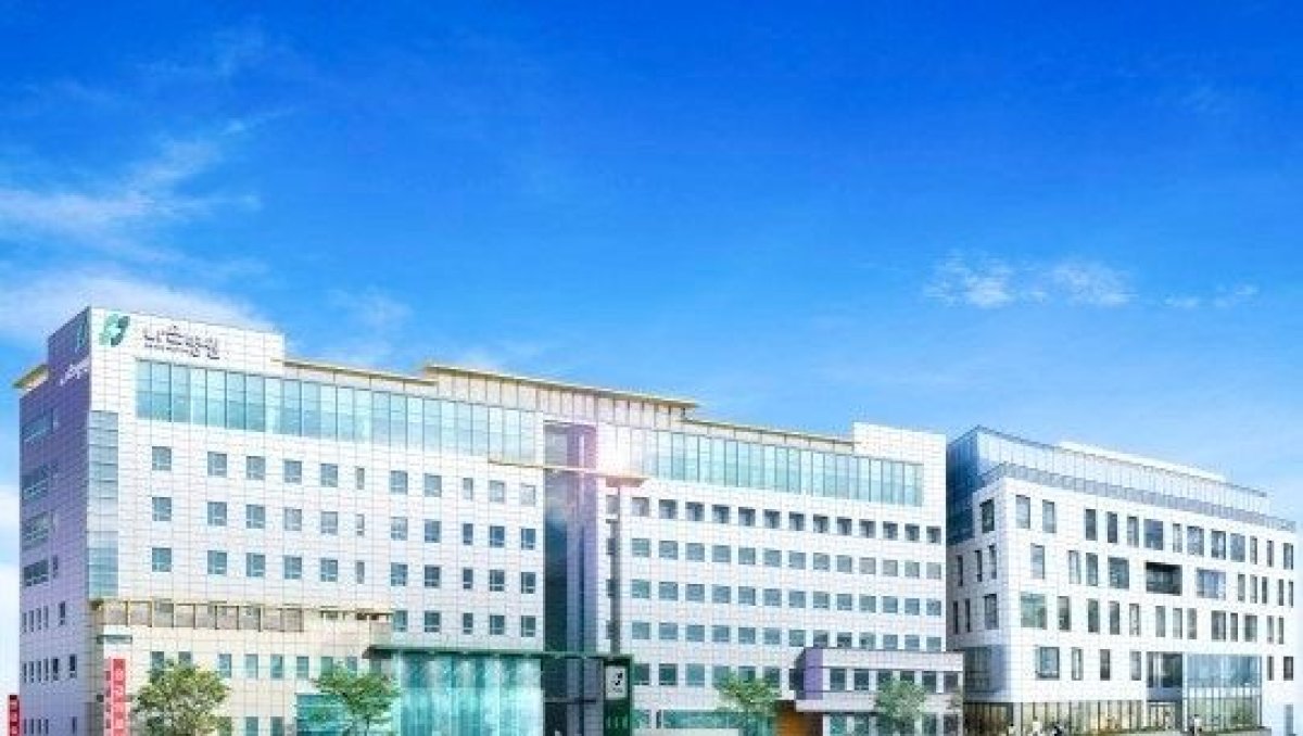 Современное здание клиники JIAN Health Promotion Center на фоне ясного неба