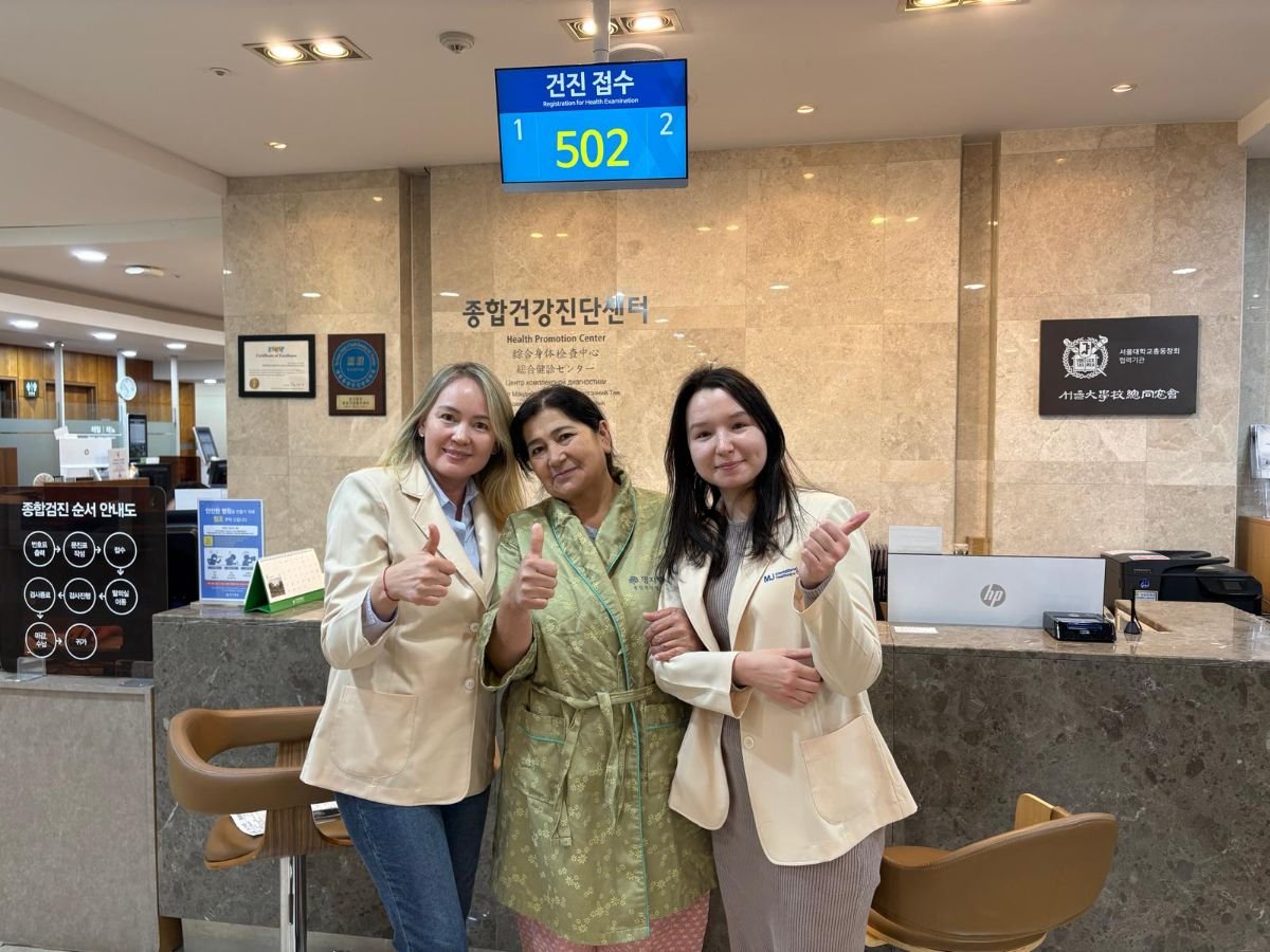 Пациент с персоналом на ресепшене JIAN Health Promotion Center после успешного лечения