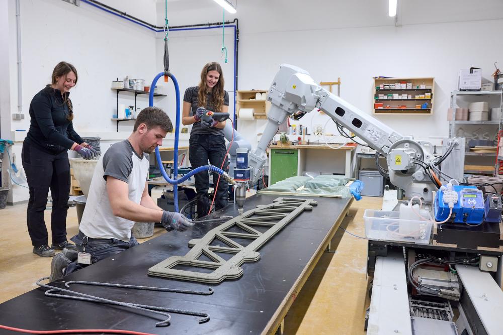 Menschen schauen auf ein 3D-gedrucktes Betonteil