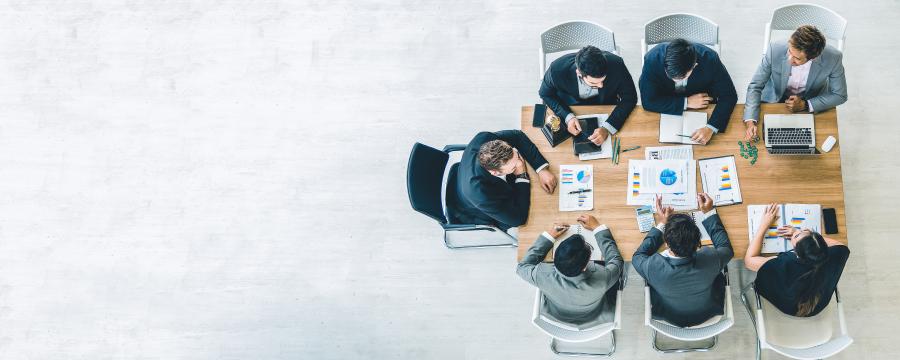 Menschen sitzen an einem Bürotisch