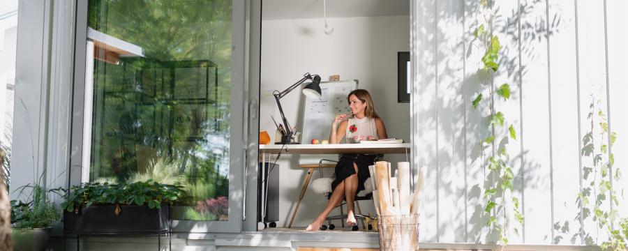 Frau sitzt im Home office im Container