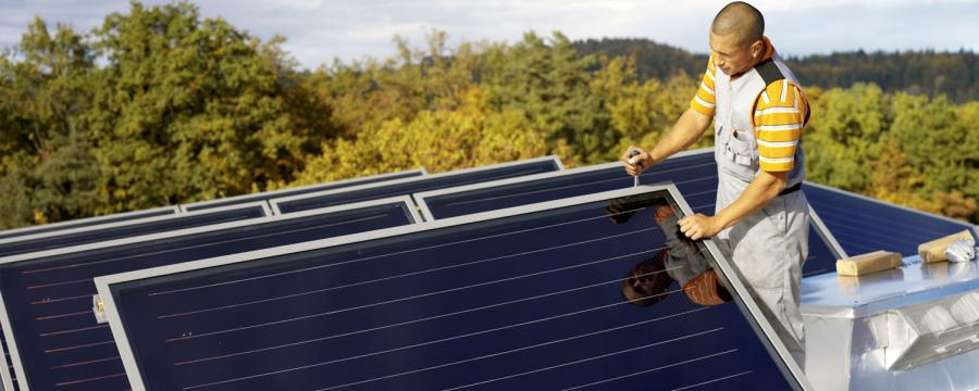 Mann neben einem Solarpanel