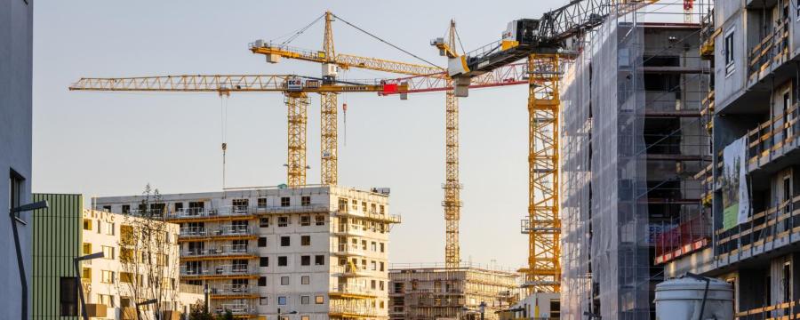 Baukräne inmitten von mehrgeschossigen Wohnhäusern im Rohbau
